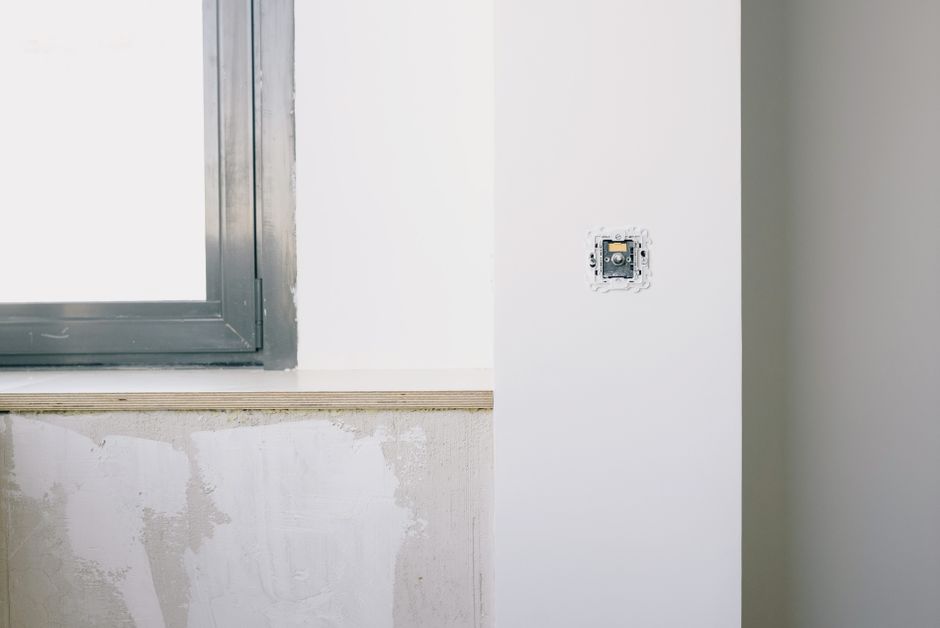 A bright room with a window in a white wall.